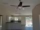 Spacious kitchen featuring sleek black countertops, white cabinets, and a modern ceiling fan at 1 Fisher Lane Way, Ocklawaha, FL 32179
