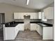 Modern kitchen features white cabinets, sleek black countertops, and new appliances, offering a stylish cooking space at 1 Fisher Lane Way, Ocklawaha, FL 32179