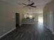 Bright, open living room with modern flooring leading to a well-lit kitchen and access to the backyard at 1 Fisher Lane Way, Ocklawaha, FL 32179