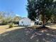 Back exterior view of the white home highlighting landscaping and a covered porch area at 10824 Sw 90Th Ter, Ocala, FL 34481