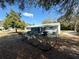 Backyard view of the home featuring a fenced-in yard, screened porch, and mature trees at 10824 Sw 90Th Ter, Ocala, FL 34481