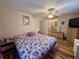 Bedroom with ceiling fan, ensuite bathroom access, and adjacent decorative dresser and chest at 10824 Sw 90Th Ter, Ocala, FL 34481