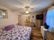 Bedroom with attached bath featuring a ceiling fan, closet, and hardwood floors at 10824 Sw 90Th Ter, Ocala, FL 34481