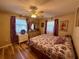 Bedroom featuring a ceiling fan, window, closet, and hardwood floors at 10824 Sw 90Th Ter, Ocala, FL 34481