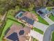 Aerial view of a home with solar panels and a screened-in pool, surrounded by a well-maintained lawn at 11084 Se 168Th Loop, Summerfield, FL 34491