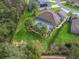 An aerial view of the backyard with a screened in pool and lots of palm trees at 11084 Se 168Th Loop, Summerfield, FL 34491