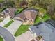 Aerial shot of a property featuring solar panels, a screened pool, a three-car garage, and lush landscaping at 11084 Se 168Th Loop, Summerfield, FL 34491