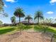 Landscaped backyard with palm trees, rock ground cover, and a screened-in pool and spa at 11084 Se 168Th Loop, Summerfield, FL 34491