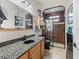 Bathroom showcasing granite countertops, wood cabinets, and a glass-enclosed shower with a tiled surround and a black toilet at 11084 Se 168Th Loop, Summerfield, FL 34491