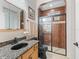 Bathroom featuring wood cabinets, granite countertop, framed mirrors, and a modern glass shower with tile at 11084 Se 168Th Loop, Summerfield, FL 34491