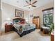 Bright bedroom with a ceiling fan, tile floors, a patterned quilt, and comfortable sitting area by the window at 11084 Se 168Th Loop, Summerfield, FL 34491