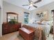 Bedroom with a wooden chest, a lush fern display, a floral comforter, and natural light from a window at 11084 Se 168Th Loop, Summerfield, FL 34491