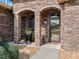 Close-up view of the home's entrance with stone arches, attractive landscaping, and a modern glass front door at 11084 Se 168Th Loop, Summerfield, FL 34491