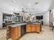 Open kitchen featuring a granite-topped island, stone accents, wooden cabinets, and modern black appliances at 11084 Se 168Th Loop, Summerfield, FL 34491