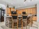 Kitchen island with seating and granite countertops, complemented by wooden cabinetry and modern appliances at 11084 Se 168Th Loop, Summerfield, FL 34491