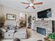 Cozy living room featuring a stone fireplace, ceiling fan, and comfortable seating at 11084 Se 168Th Loop, Summerfield, FL 34491