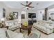 Comfortable living room featuring plush sofas, a ceiling fan, tile floors, and a decorative stone archway at 11084 Se 168Th Loop, Summerfield, FL 34491