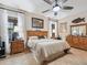 Spacious main bedroom with ceiling fan, natural light, and wood furniture at 11084 Se 168Th Loop, Summerfield, FL 34491