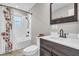 Bathroom featuring tile flooring, shower and tub combo, and a dark wood vanity at 11619 Lane Park Rd, Tavares, FL 32778