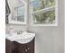 Bathroom sink with a dark wood cabinet and bright, natural light coming from the window at 11619 Lane Park Rd, Tavares, FL 32778