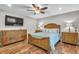 Bedroom showcasing wood floors, matching dresser and nightstands, and ceiling fan at 11619 Lane Park Rd, Tavares, FL 32778