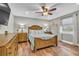 Bedroom with light grey walls, wood floors, ceiling fan, and natural light from the exterior window at 11619 Lane Park Rd, Tavares, FL 32778