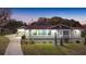 Inviting home exterior at twilight featuring manicured landscaping and a winding driveway at 11619 Lane Park Rd, Tavares, FL 32778