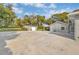 View of the side of the gray home, with a large concrete drive and a detached storage shed at 11619 Lane Park Rd, Tavares, FL 32778