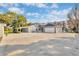 Stunning home with a huge concrete driveway and an attached two-car garage, all under a beautiful blue sky at 11619 Lane Park Rd, Tavares, FL 32778