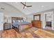 Well-lit main bedroom with a hardwood floor, ceiling fan, dresser, and an ensuite bathroom at 11619 Lane Park Rd, Tavares, FL 32778