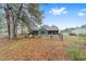 View of the backyard with a fire pit, chairs, and a screened patio, all enclosed by a chain-link fence at 11725 79Th Cir, Ocala, FL 34476