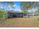 View of the fenced backyard featuring a large screened patio and sunroom addition on the house at 11725 79Th Cir, Ocala, FL 34476