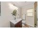 Bathroom featuring a modern vanity with a dark wood cabinet and oval mirror and a window at 11725 79Th Cir, Ocala, FL 34476