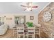 Open dining area featuring a farmhouse table, brick wall and view of living room at 11725 79Th Cir, Ocala, FL 34476