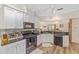 Bright kitchen featuring white cabinetry, black appliances and view of eat-in area at 11725 79Th Cir, Ocala, FL 34476