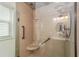 Accessible shower featuring grab bars, built-in seating, and glass doors for easy maintenance at 11725 79Th Cir, Ocala, FL 34476