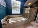 Stylish bathroom featuring garden tub, glass door shower, and bright window for lots of natural light at 130 Harbour Cove Way, Clermont, FL 34711