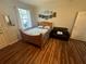 Cozy bedroom featuring a wooden bed frame, accent chair, and natural light from the nearby window at 130 Harbour Cove Way, Clermont, FL 34711