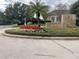 Community entrance sign featuring stone details, lush landscaping and mature palm trees at 130 Harbour Cove Way, Clermont, FL 34711