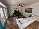 Cozy living room with hardwood floors, a ceiling fan, TV, and french doors leading to the outside at 130 Harbour Cove Way, Clermont, FL 34711