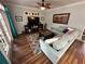 Living room with hardwood floors, a ceiling fan, french doors, an area rug, and a large couch at 130 Harbour Cove Way, Clermont, FL 34711