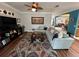 Comfortable living room with large sectional sofa, hardwood floors, colorful rug, and ceiling fan at 130 Harbour Cove Way, Clermont, FL 34711