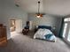 Spacious bedroom with vaulted ceiling, ceiling fan, and doorway leading to luxurious en-suite bathroom at 130 Harbour Cove Way, Clermont, FL 34711