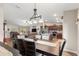 View of dining room with a rustic table and kitchen with stainless steel appliances and granite countertops at 13057 Sw 85Th Cir, Ocala, FL 34473