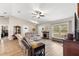 Comfortable living room with hardwood floors, a ceiling fan, and large windows, creating a welcoming atmosphere at 13057 Sw 85Th Cir, Ocala, FL 34473