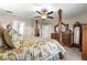 Serene main bedroom featuring a four-poster bed, ceiling fan, and ensuite bathroom, creating a private retreat at 13057 Sw 85Th Cir, Ocala, FL 34473