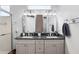 Bathroom featuring double vanity with gray cabinets, a dark countertop and a decorative mirror cabinet at 13187 Se 93Rd Terrace Rd, Summerfield, FL 34491