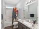 Bathroom with a shower/tub combo with grey marble counters and an eclectic and colorful shower curtain at 13187 Se 93Rd Terrace Rd, Summerfield, FL 34491