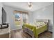 Bedroom featuring a large window, ceiling fan, light blue walls, and wood look floors at 13187 Se 93Rd Terrace Rd, Summerfield, FL 34491