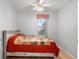 Cozy bedroom featuring hardwood floors, neutral paint, a window with red checked curtains, and ceiling fan at 13187 Se 93Rd Terrace Rd, Summerfield, FL 34491